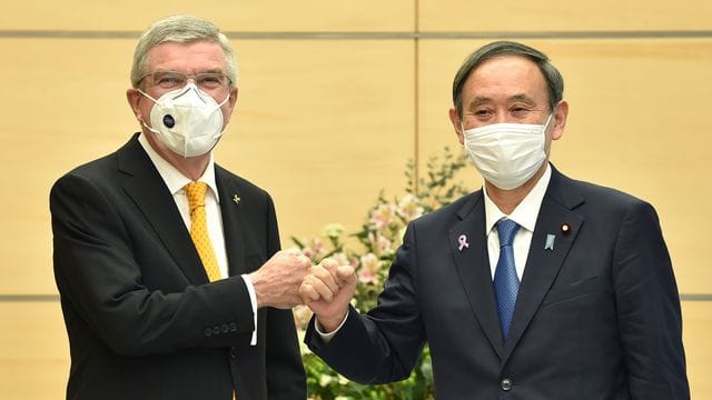 IOC-Präsident Thomas Bach (l) und Japans Premierminister Yoshihide Suga begrüßen sich. IOC-Präsident Thomas Bach (l) und Japans Premierminister Yoshihide Suga begrüßen sich.