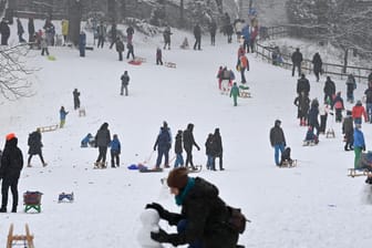 Erwachsene und Kinder genießen in den Maximiliansanlagen nahe dem bayerischen Landtag die frisch verschneiten Hügel: Wegen des Ansturms musste die Polizei in Teilen von München eingreifen.