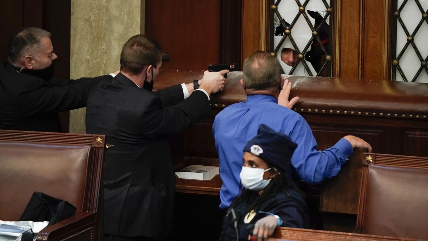 Im Kapitol: Polizisten mit gezogenen Waffen beobachten, wie Demonstranten versuchen, in die Kammer des Repräsentantenhauses im US-Kapitol einzudringen.