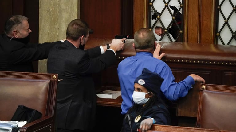 Im Kapitol: Polizisten mit gezogenen Waffen beobachten, wie Demonstranten versuchen, in die Kammer des Repräsentantenhauses im US-Kapitol einzudringen.