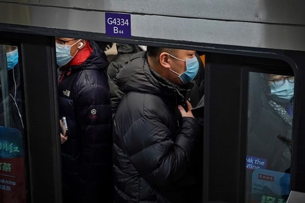Pendler in Peking drängen sich während der Hauptverkehrszeit in eine U-Bahn.