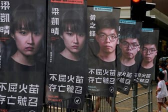 Banner des prodemokratischen Kandidaten Joshua Wong sind vor einer U-Bahn-Station zu sehen.
