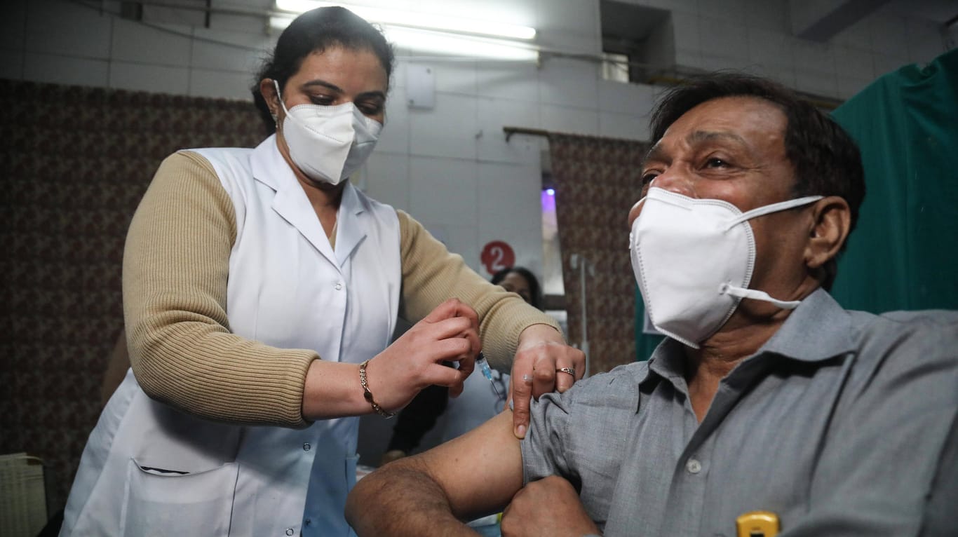 Eine Mitarbeiterin des Gesundheitswesens impft in Neu Delhi einen Mann: Inzwischen sind in Indien zwei Impfstoffe zugelassen.