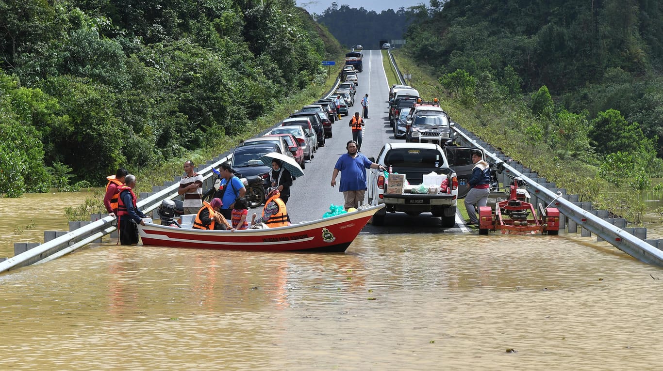 Malaysia unter Wasser: Ein Boot bringt Anwohner nach starken Regenfällen über eine überflutete Straße.