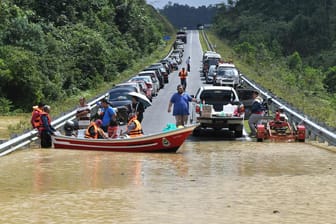 Malaysia unter Wasser: Ein Boot bringt Anwohner nach starken Regenfällen über eine überflutete Straße.