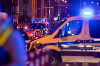 Einsatzkräfte der Polizei und Feuerwehr stehen bei ihren Fahrzeugen. Bei einem Polizeieinsatz in Mülheim ist ein mit einem Gewehr bewaffneter Mann durch einen Schuss tödlich verletzt worden.