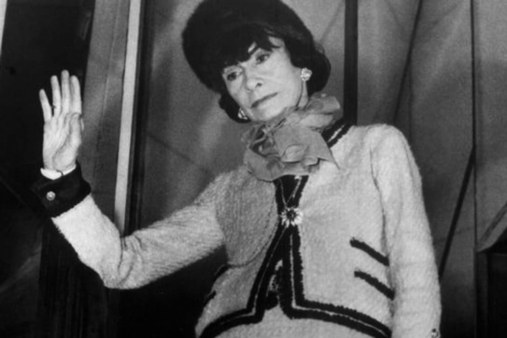 Die französische Modeschöpferin Coco Chanel in einem von ihr entworfenen "Chanel-Kostüm".