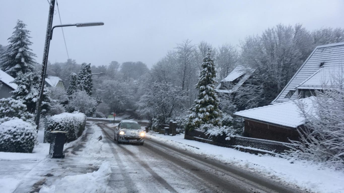 Ein Auto fährt auf dem verschneiten Westfalenweg in Wuppertal: In der Nacht hat es dort geschneit.