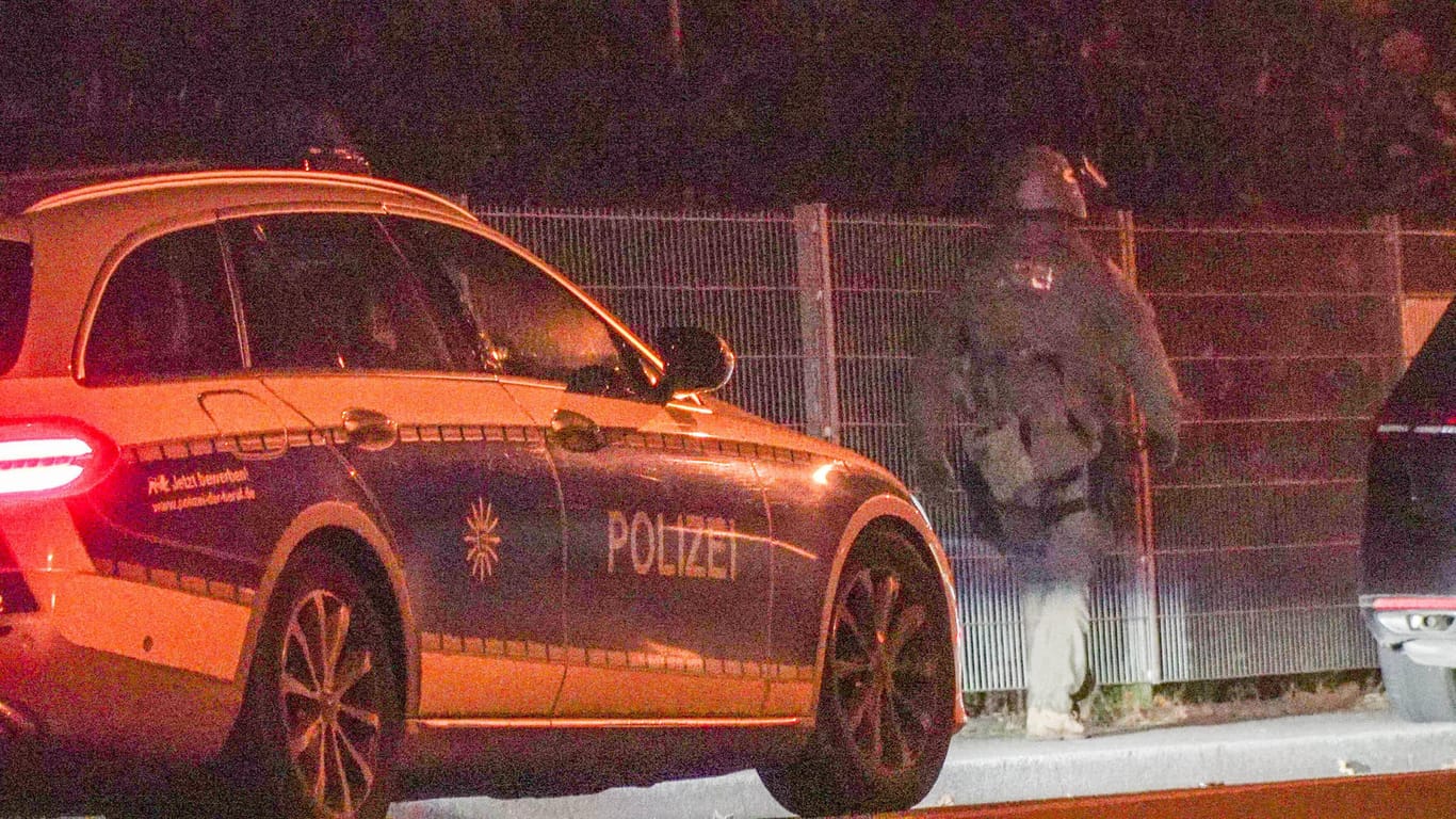 Ein Polizeiauto und ein Mann in SEK-Uniform bei einem Einsatz (Archivbild): In Mönchengladbach hat es nach einer Tat in Essen einen SEK-Einsatz gegeben.