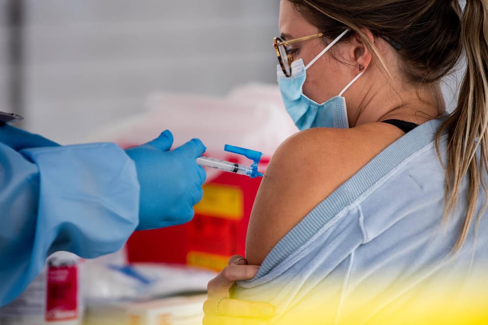 Eine junge Frau wird gegen das Coronavirus geimpft: Der Impfstoff soll vorerst auch bei den neuen Virus-Varianten wirksam sein.