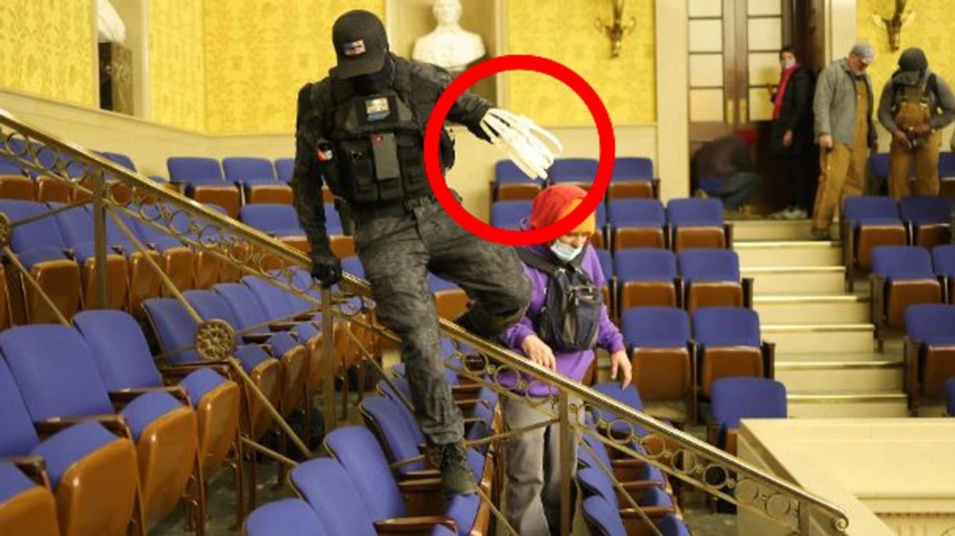 Ein Maskierter in der Senatskammer des Kapitols: Mehrere Männer wurden mit den Spezialhandschellen gesichtet. Mindestens einer von ihnen ist ein Ex-Militär.