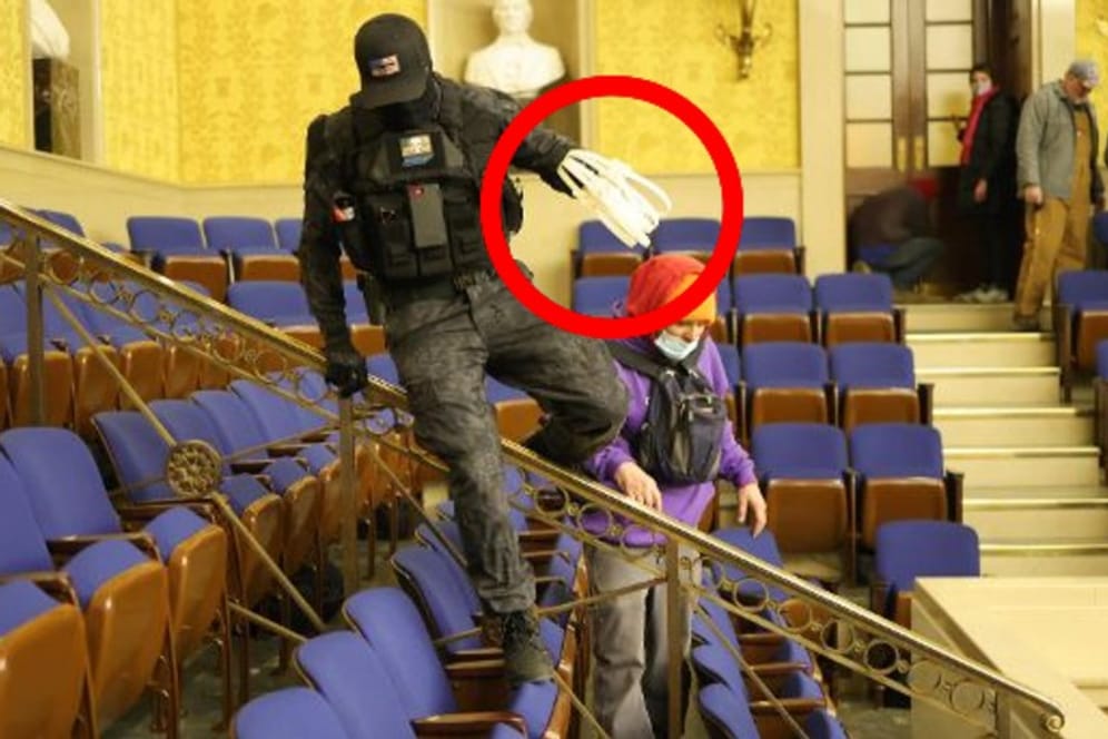 Ein Maskierter in der Senatskammer des Kapitols: Mehrere Männer wurden mit den Spezialhandschellen gesichtet. Mindestens einer von ihnen ist ein Ex-Militär.