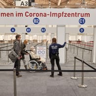 Eine Frau im Rollstuhl und Begleitpersonen lassen sich am Eingangsbereich des Corona-Impfzentrums in Hamburg: "Wir können erst richtig durchstarten, wenn mehr Impfstoff vor Ort ankommt."