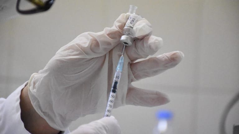 Eine Person zieht Impfstoff in einer Spritze auf (Symbolbild): Berliner Behörden haben Impfeinladungen an Verstorbene versendet.