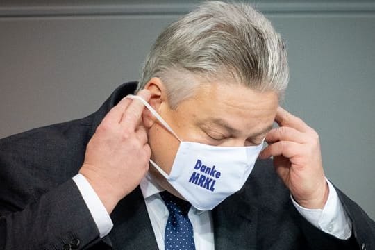 Thomas Seitz (AfD) trägt eine Maske, auf der "Danke MRKL" steht