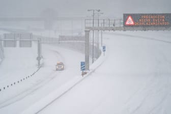 Ein Rettungsfahrzeug fährt auf der leeren, schneebedeckten Schnellstraße M-30 in Madrid.