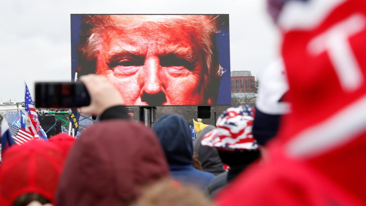 US-Präsident Donald Trump auf einer Leinwand vor seinen Anhängern: Weil er die Menge zum Sturm auf das Kapitol angestiftet hat, soll er nun aus dem Amt geworfen werden.