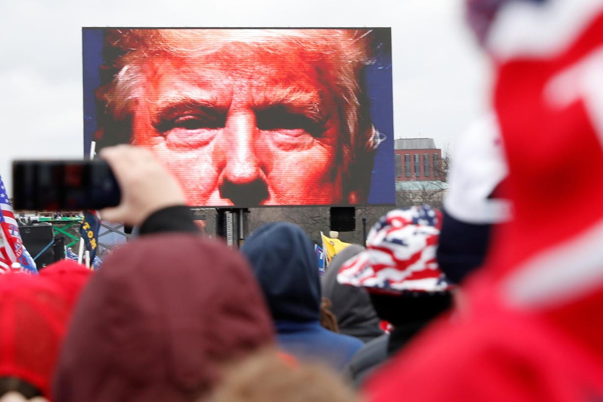 US-Präsident Donald Trump auf einer Leinwand vor seinen Anhängern: Weil er die Menge zum Sturm auf das Kapitol angestiftet hat, soll er nun aus dem Amt geworfen werden.