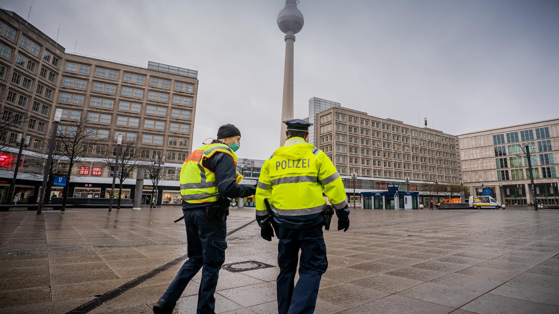 Polizisten gehen über den ansonsten weitgehend leeren Alexanderplatz: Die meisten Geschäfte müssen im Lockdown geschlossen bleiben.