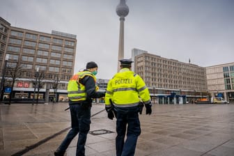 Polizisten gehen über den ansonsten weitgehend leeren Alexanderplatz: Die meisten Geschäfte müssen im Lockdown geschlossen bleiben.