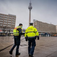 Polizisten gehen über den ansonsten weitgehend leeren Alexanderplatz: Die meisten Geschäfte müssen im Lockdown geschlossen bleiben.