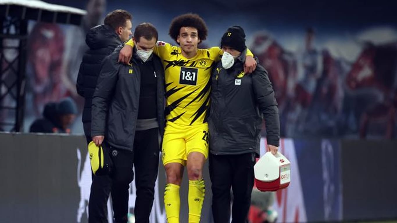 Dortmunds Axel Witsel wird von BVB-Betreuern verletzt vom Platz geführt.