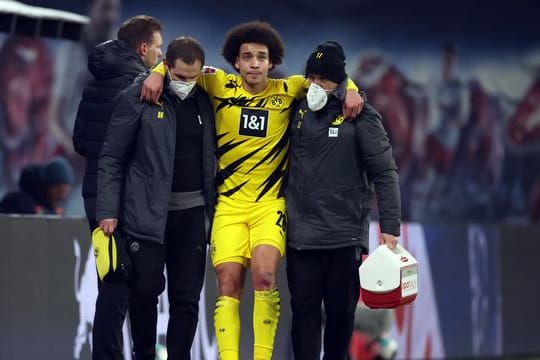 Dortmunds Axel Witsel wird von BVB-Betreuern verletzt vom Platz geführt.