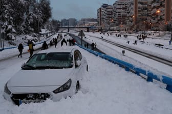 Keine Weiterfahrt möglich: Ein Auto steckt auf einer Schnellstraße in Madrid fest. Die Anwohner nutzen die Straße als Fußweg.