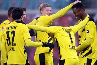 Dortmunds Spieler feiern Erling Haaland (M) nach dessen Treffer zum 3:0 gegen RB Leipzig.