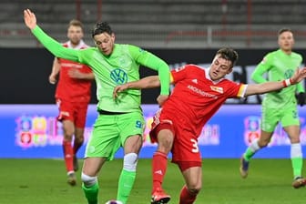 Robin Knoche (r) von Union Berlin im Duell um den Ball mit Wolfsburgs Wout Weghorst.