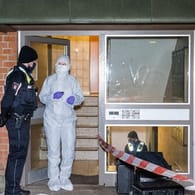 Polizisten und Mitarbeiter der Spurensicherung vor dem Mehrfamilienhaus in Hamburg-Neuallermöhe: Hier wurde eine weibliche Leiche gefunden.