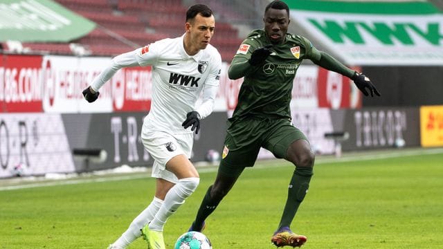 Augsburgs Iago (l) und Stuttgarts Silas Wamangituka im Zweikampf um den Ball. Augsburgs Iago (l) und Stuttgarts Silas Wamangituka im Zweikampf um den Ball.