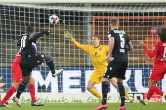Bielefelds Reinhold Yabo (l) erzielt den Treffer zum 1:0 gegen Herthas Torwart Alexander Schwolow (M).