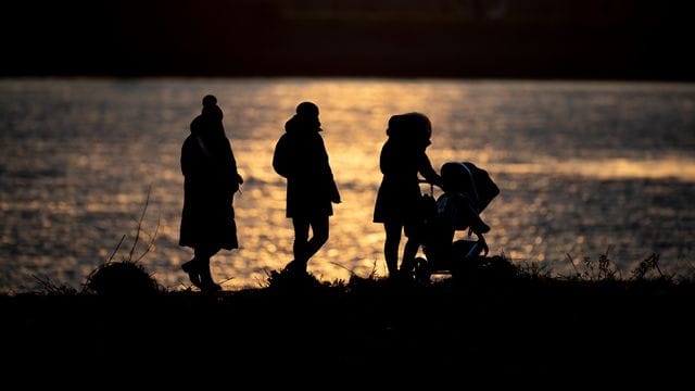 Frische Luft schnappen: Eine Familie ist bei sonnigem Wetter in Hamburg unterwegs.
