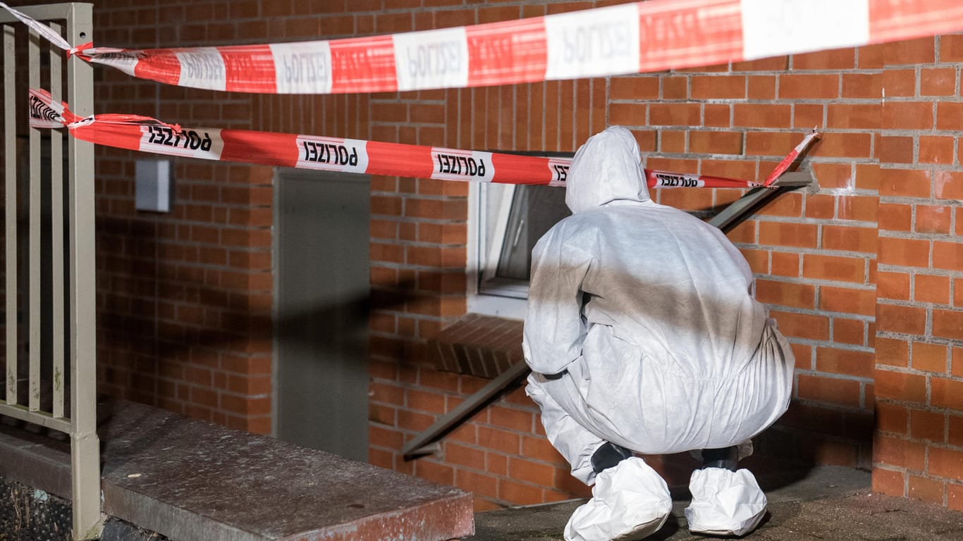 Ein Mitarbeiter der Spurensicherung steht im Stadtteil Neuallermöhe am Kellerzugang eines Mehrfamilienhauses: Eine Frau wurde hier tot aufgefunden.