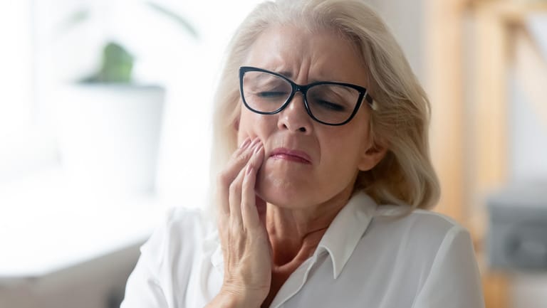 Frau hat Zahnschmerzen: Mit zunehmendem Alter treten Zahnprobleme immer häufiger auf.