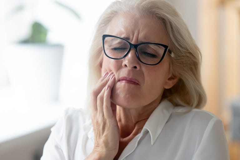 Frau hat Zahnschmerzen: Mit zunehmendem Alter treten Zahnprobleme immer häufiger auf.