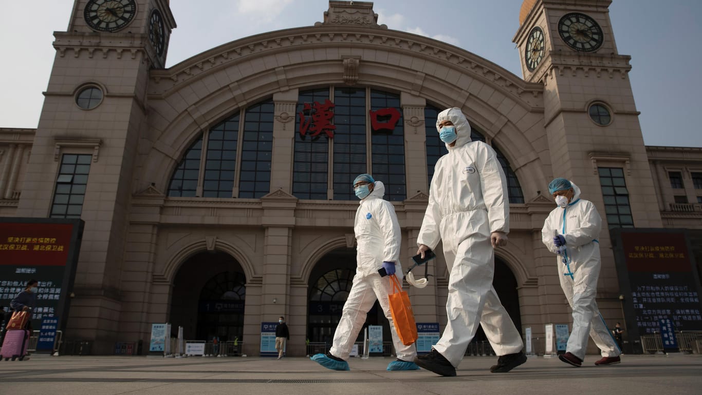 Arbeiter in Schutzanzügen am Bahnhof von Hankou: Die chinesische Regierung präsentiert sich als Sieger gegen das Coronavirus.