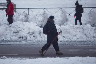 Menschen in den schneebedeckten Straßen von Madrid: Nur wenige Fahrzeuge sind unterwegs.