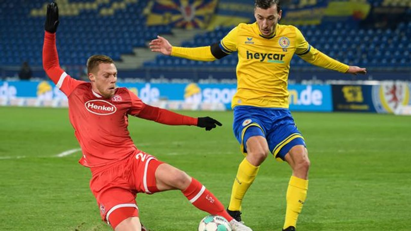 Braunschweigs Dominik Wydra (r) und Rouwen Hennings von Fortuna Düsseldorf kämpfen um den Ball.