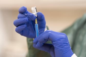 Eine Person mit blauen Gummihandschuhen zieht mit einer Spritze den Corona-Impfstoff auf (Symbolbild): Auf der Internetseite der Kassenärztlichen Vereinigung Westfalen-Lippe kann nun geschaut werden, wie viele Personen bereits geimpft worden sind.