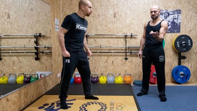 Frank Stäbler (l) bläst während eines Atemtrainings eine Kerze aus, die sein Atemtrainer Yasin Seiwasser hält.