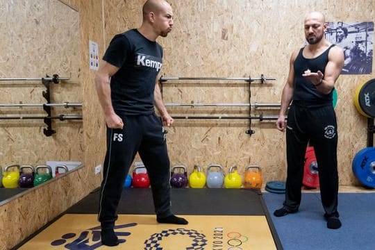 Frank Stäbler (l) bläst während eines Atemtrainings eine Kerze aus, die sein Atemtrainer Yasin Seiwasser hält.