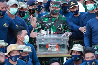 Personal der indonesischen Marine und der Flugschreiber: Bereits am Sonntag war der Flugschreiber geortet worden, am Dienstag konnte er dann geborgen werden.