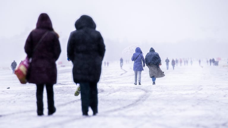 Berliner spazieren bei Schneefall über das Tempelhofer Feld (Archivbild): Blitzeis verursachte zahlreiche Unfälle in der Region