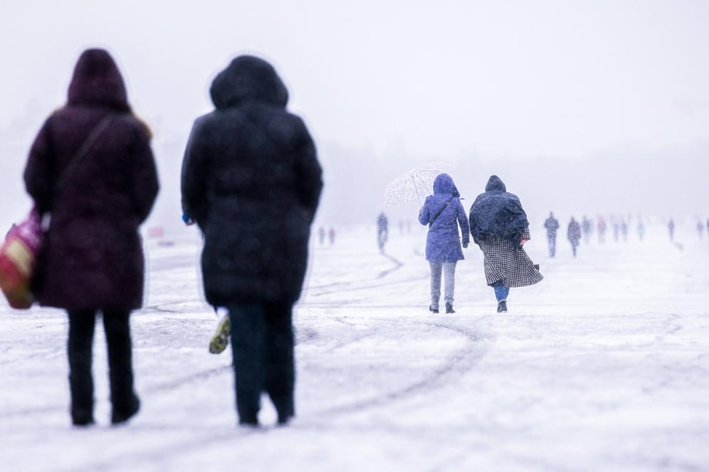 Berliner spazieren bei Schneefall über das Tempelhofer Feld (Archivbild): Blitzeis verursachte zahlreiche Unfälle in der Region
