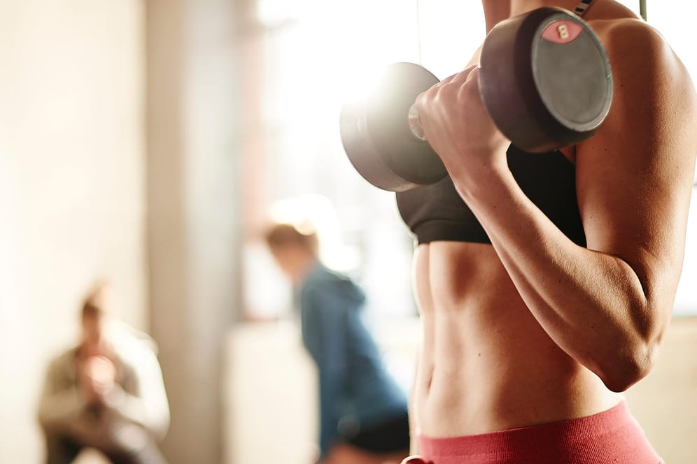 Eine Frau trainiert mit Hanteln (Symbolbild): Um Fitnessstudio-Verträge vorzeitig kündigen zu dürfen, brauchen Sie einen guten Grund.