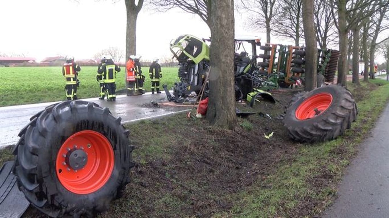 Unfallstelle in Niedersachsen: Die bei einem Unfall abgerissenen Reifen eines völlig zerstörten Traktors liegen in einem Straßengraben.