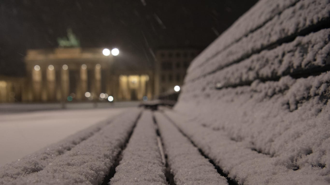 Schnee liegt auf einer Bank auf dem Pariser Platz vor dem Brandenburger Tor in Berlin: In der Hauptstadt und in Brandenburg wird es die nächsten Tage kalt.