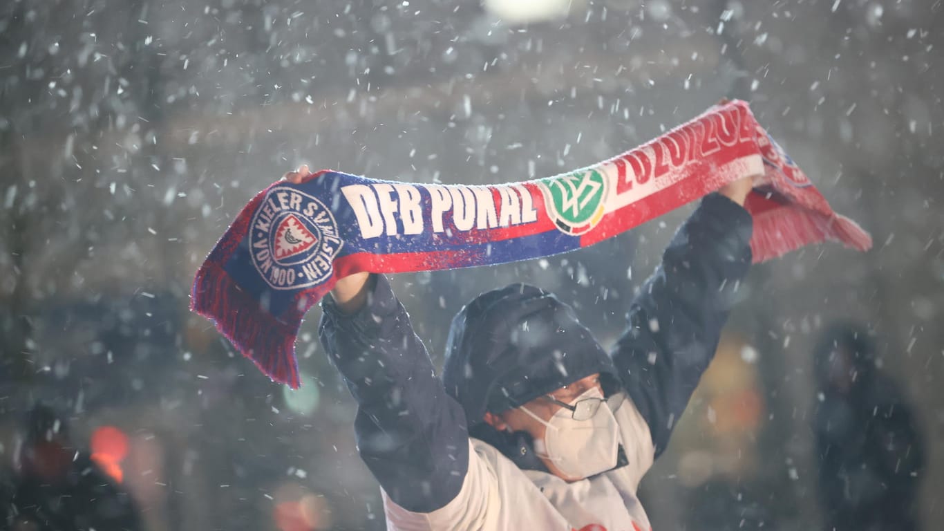 Ein Kieler Fan hält einen Schal hoch: Trotz Corona wurde rund um das Stadion gefeiert.
